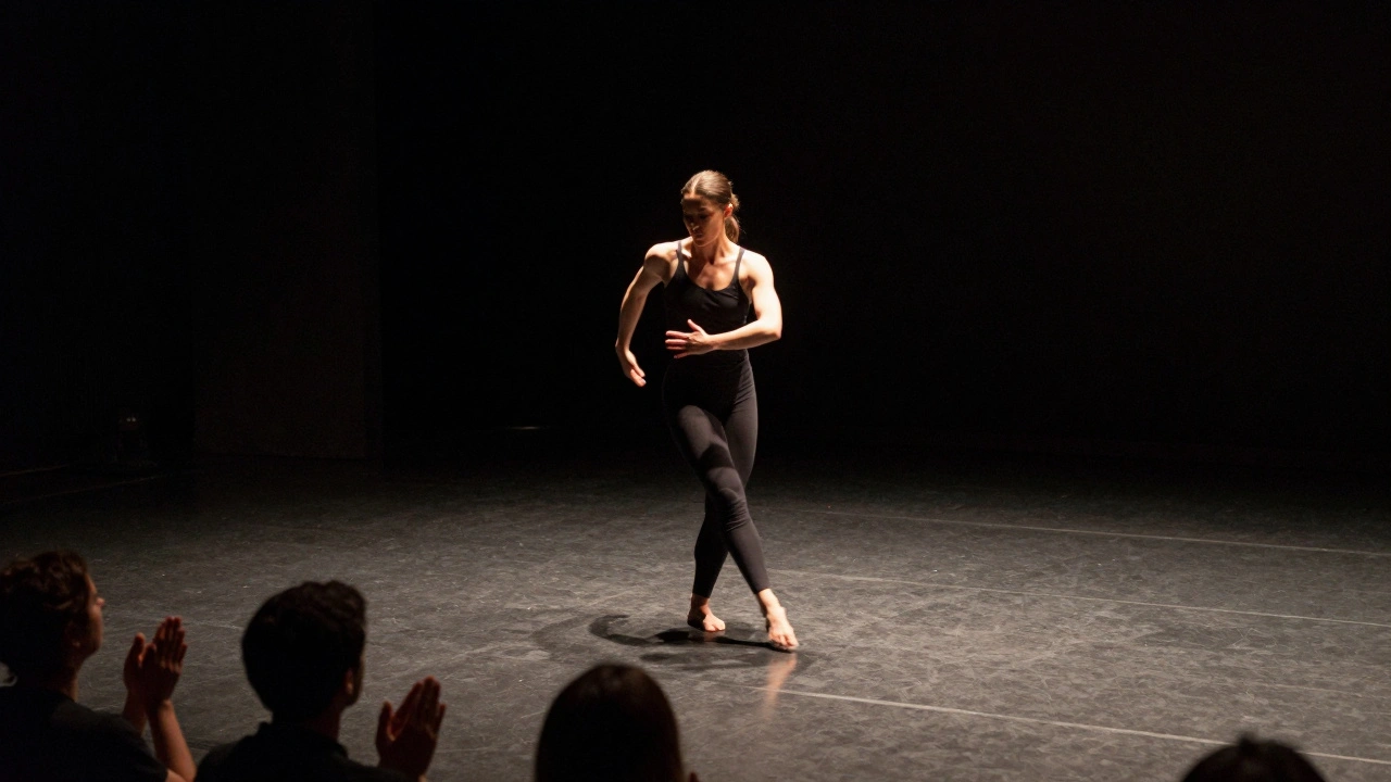 A performer glides across a dark stage with precise, intentional movement, spotlight highlighting her controlled motion.